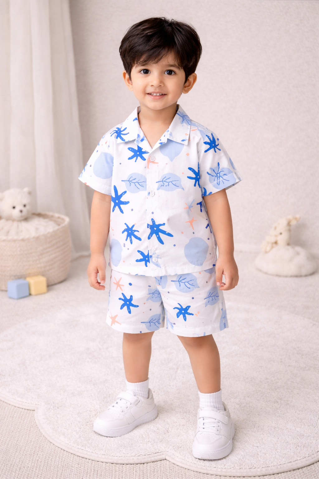 "Two young boys wearing matching summer sets, smiling, studio setting."