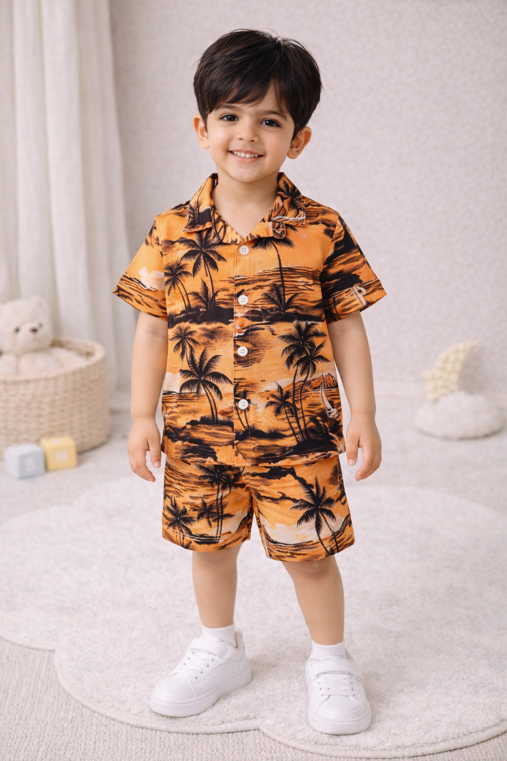 "Two young boys wearing matching summer sets, smiling, studio setting."